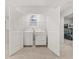 A well-lit laundry room is showcased with a washer and dryer and complemented by wide-swinging white doors at 3081 Greyton Dr, Buford, GA 30519