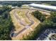 Aerial view of newly developed land, showcasing street layout amidst surrounding greenery and nearby buildings at 3101 Greyton Dr, Buford, GA 30519