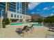 Luxury high-rise exterior featuring a large swimming pool and lounge area with blue skies at 2233 Peachtree Ne Rd # 1202, Atlanta, GA 30309