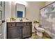 Modern bathroom featuring a dark vanity, framed mirror and decorative shower curtain at 4750 Fields Bridge Rd, Cumming, GA 30028