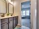 Bathroom with double vanity and framed mirrors leading into a bedroom with natural light at 4750 Fields Bridge Rd, Cumming, GA 30028