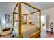 Well-lit bedroom with a four-poster bed, offering a view into an adjacent bathroom with modern fixtures at 4750 Fields Bridge Rd, Cumming, GA 30028