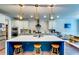 Modern kitchen featuring a large island, stylish stools, stainless appliances and contemporary lighting at 4750 Fields Bridge Rd, Cumming, GA 30028