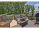 Outdoor deck featuring wicker seating, a grill, and a fire pit with wooded scenery at 48 Scenic Ovlk, Acworth, GA 30101