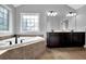 Bright bathroom featuring a soaking tub with tile surround, a decorative window, and a vanity with double sinks at 48 Scenic Ovlk, Acworth, GA 30101