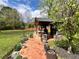 Brick pathway leading to an outdoor kitchen featuring a built-in grill and a well-manicured lawn at 1164 Sandtown Sw Rd, Marietta, GA 30008