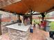 Outdoor kitchen with a granite countertop, bar seating, and a beautiful wood ceiling for backyard gatherings at 1164 Sandtown Sw Rd, Marietta, GA 30008