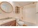 Bathroom with light brown wood vanity, round mirror, shower-tub, toilet, and beige walls at 60 Kyler Way Way, Dallas, GA 30157