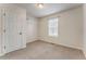 Simple bedroom featuring neutral carpet, white walls, door, one window, and closet shelving at 60 Kyler Way Way, Dallas, GA 30157