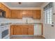 Kitchen featuring wood cabinets, a sink, white appliances, and a door with a window at 60 Kyler Way Way, Dallas, GA 30157