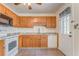 Well-lit kitchen featuring wood cabinets, white appliances, and tiled flooring at 60 Kyler Way Way, Dallas, GA 30157