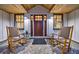 Inviting front porch featuring rocking chairs and a brick-laid floor leading to a wood front door at 180 Saddle Creek Dr, Roswell, GA 30076