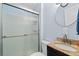 Bathroom featuring granite countertop, glass door, walk in shower, and large round mirror at 1981 Lindsey Ln, Decatur, GA 30035