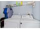 Functional laundry room equipped with a white washer and dryer and overhead storage shelves at 1981 Lindsey Ln, Decatur, GA 30035