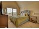 Cozy bedroom features a tufted headboard, neutral walls, and a large window for natural light at 200 Baumgard Way, Locust Grove, GA 30248