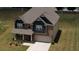 Aerial view of a two-story home with brick and blue siding, well-manicured lawn, and a driveway leading to the garage at 200 Baumgard Way, Locust Grove, GA 30248