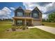 Charming two-story home with a well-maintained lawn, beautiful brickwork, blue siding, and an attached two-car garage at 200 Baumgard Way, Locust Grove, GA 30248