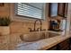 Close-up of a kitchen sink with granite countertops, a modern faucet, and tile backsplash at 200 Baumgard Way, Locust Grove, GA 30248