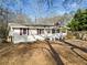Charming single-story home with white siding, brick chimney, and a lovely front porch at 2570 Curtis Sw Rd, Marietta, GA 30064