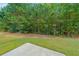 Backyard featuring a lush green lawn and a serene view of the surrounding woods at 4007 Fellowship Dr, Buford, GA 30519