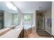 Bathroom with tiled floor and shower, garden tub under window, and vanity at 4007 Fellowship Dr, Buford, GA 30519