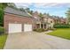 Spacious driveway leading to a brick home with a two-car garage and well-manicured landscaping at 4007 Fellowship Dr, Buford, GA 30519