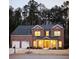 Charming brick home at dusk with a two-car garage and inviting front porch, set against a backdrop of tall trees at 4007 Fellowship Dr, Buford, GA 30519