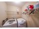 Bright laundry room with white washer and dryer, and wire shelving at 4007 Fellowship Dr, Buford, GA 30519