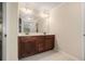 Bathroom with a dual sink vanity featuring wood cabinets, ample countertop space, and decorative lighting at 5288 Clingman Ct, Douglasville, GA 30135