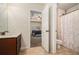 Bathroom with wood vanity and view to the bedroom; features neutral tile flooring at 5288 Clingman Ct, Douglasville, GA 30135