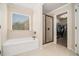 Bathroom showcasing a soaking tub, frameless glass shower, and access to a walk-in closet for an organized, spa-like experience at 5288 Clingman Ct, Douglasville, GA 30135