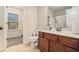 Cozy bathroom featuring a white toilet and vanity with dark wood cabinets and marble top at 5288 Clingman Ct, Douglasville, GA 30135
