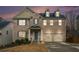 Charming two-story brick home featuring blue shutters, a two-car garage, and a cozy front porch at 5288 Clingman Ct, Douglasville, GA 30135