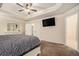 Bright main bedroom featuring tray ceiling, ceiling fan and a modern flat screen TV for a comfortable relaxing space at 5288 Clingman Ct, Douglasville, GA 30135