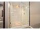 Walk-in shower features frameless glass doors, decorative tile and modern shower head and fixtures at 5288 Clingman Ct, Douglasville, GA 30135
