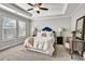 Bedroom featuring tray ceiling, a bed with plush bedding, a ceiling fan, and bright natural light at 5293 Hearthstone St, Stone Mountain, GA 30083