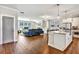 Open living space showcasing kitchen island, fireplace, hardwood floors, and a plush blue sofa at 5293 Hearthstone St, Stone Mountain, GA 30083