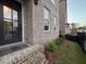 Close up of the brick facade, the front door, and landscaping around the house at 161 Wards Crossing Way # 121, Johns Creek, GA 30022