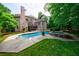 Backyard view showcasing a large swimming pool, hot tub, and multi-story brick home at 1617 Windsor Ne Pkwy, Brookhaven, GA 30319