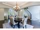 Open dining room with chandelier, hardwood floors, and views to the living room and staircase at 1617 Windsor Ne Pkwy, Brookhaven, GA 30319