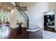 Bright foyer featuring a curved staircase, hardwood floors, and views into the living and office areas at 1617 Windsor Ne Pkwy, Brookhaven, GA 30319