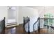 Staircase with dark hardwood floors and a black wrought iron railing leads to a landing and bright bedroom at 1617 Windsor Ne Pkwy, Brookhaven, GA 30319