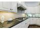 Kitchen with stainless steel range hood and cooktop along with custom backsplash and granite counters at 1617 Windsor Ne Pkwy, Brookhaven, GA 30319