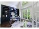Chic home office with custom shelving, a glass desk, and expansive windows offering natural light at 1617 Windsor Ne Pkwy, Brookhaven, GA 30319