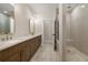 This bathroom has double sinks with granite counters, wood cabinets, mirrors, and a glass shower at 169 Wards Crossing Way # 125, Johns Creek, GA 30022