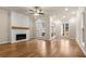 Living room featuring hardwood floors, a wood-trimmed fireplace, ceiling fan, and natural lighting at 169 Wards Crossing Way # 125, Johns Creek, GA 30022