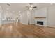 Open-concept living room showcasing hardwood floors, fireplace, and connection to the kitchen at 169 Wards Crossing Way # 125, Johns Creek, GA 30022