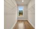 This walk-in closet has hardwood floors, a window with a view, and metal shelving along the walls at 169 Wards Crossing Way # 125, Johns Creek, GA 30022