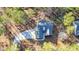 An aerial view of a modern home with a concrete driveway surrounded by mature trees on a large lot at 1312 Mcgarity Rd, Temple, GA 30179