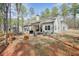 Backyard lawn with fire pit and home in the background surrounded by tall mature trees at 1312 Mcgarity Rd, Temple, GA 30179